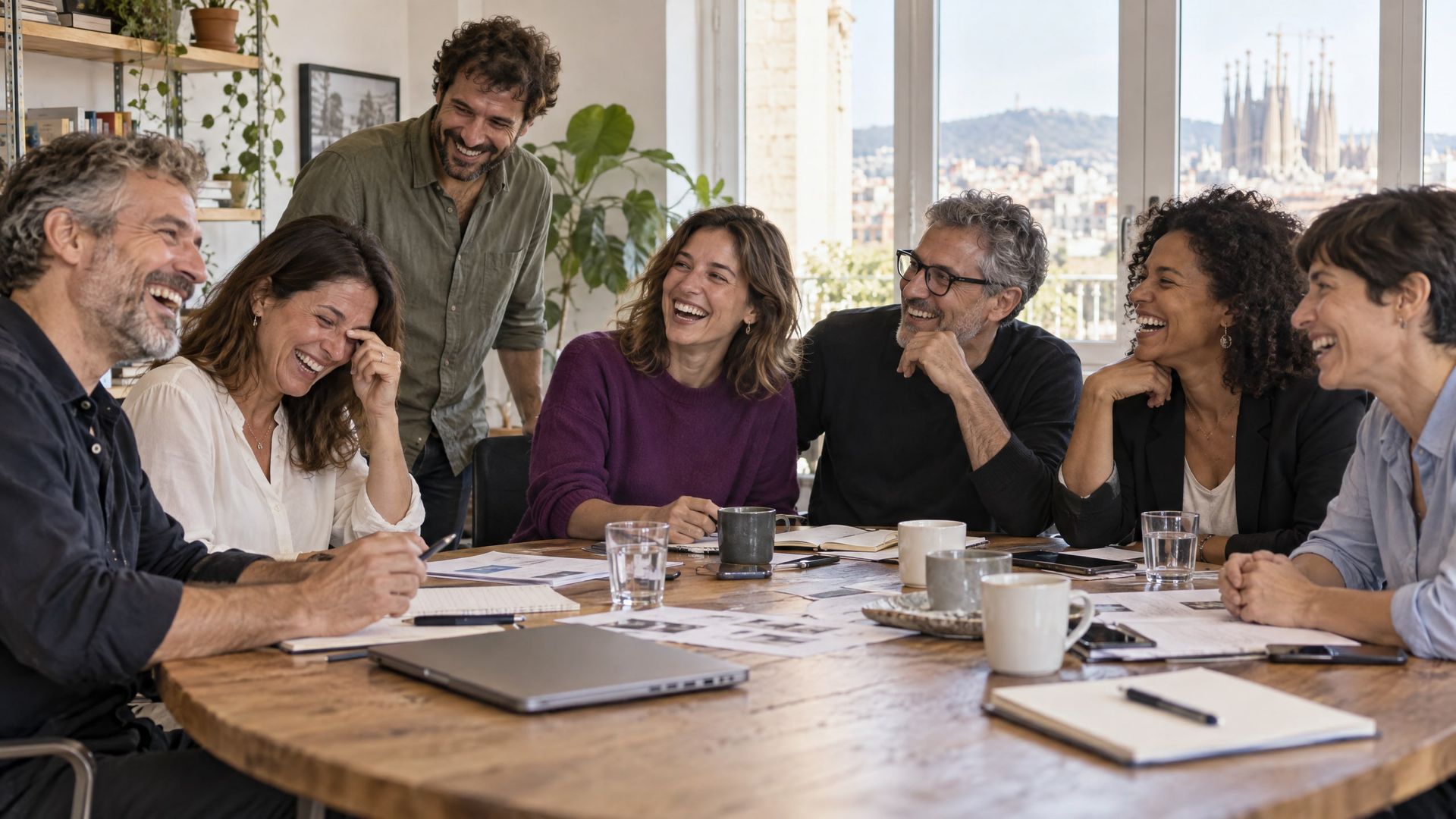 Colleagues laugh together at the end of a meeting.