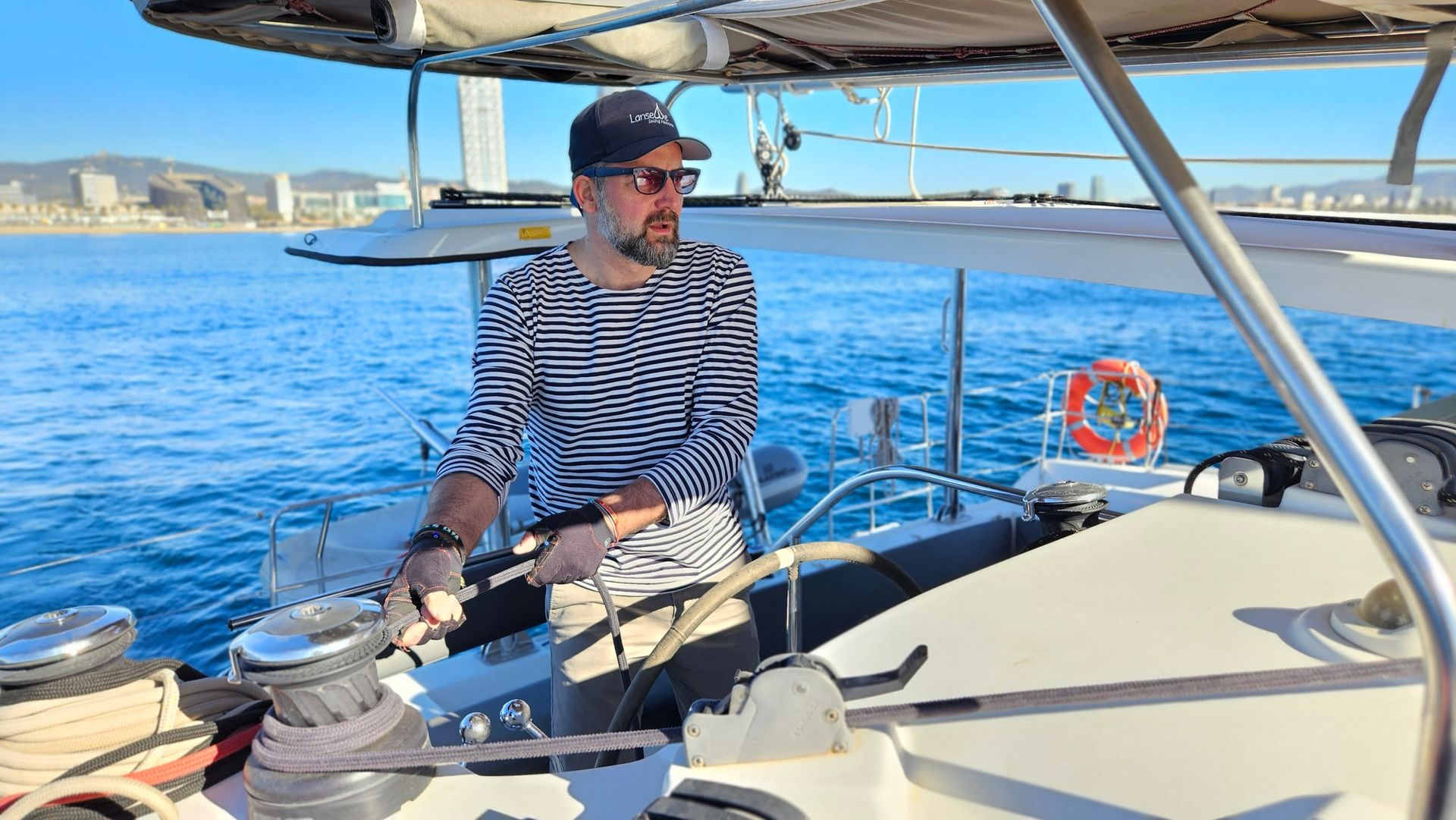 A skipper at the helm of a catamaran off Barcelona.